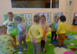 Dzieci ustawione w pary tańczą z balonami pomiędzy brzuchami.