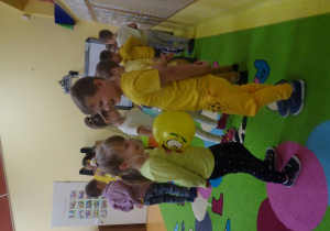 Dzieci tańczą w parach z balonem pomiędzy brzuchem z uniesionymi rękami.