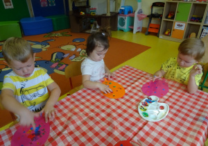 Dzieci stemplują szablony balonów palcami maczanymi w farbie.
