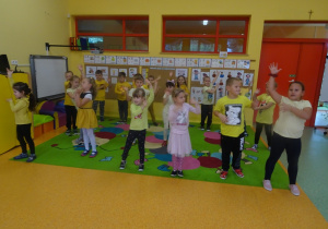 Dzieci ustawione w rozsypce tańczą.