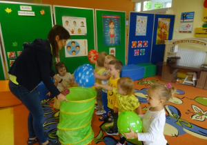 Dzieci wrzucają balony do ksoza.