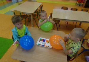 Dzieci rysują pisakami na balonach.