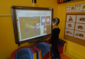 Chłopiec rozwiązuje quiz na tablicy interaktywnej.