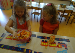 Dzieci napełniają słoiki pokrojonymi warzywami