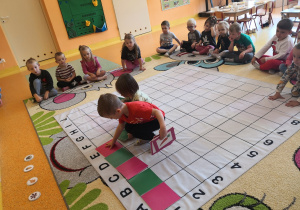 chłopcy kontynuuje rytm na macie, zaczęty przez nauczyciela - czerwony kwadrat, zielony kwadrat , czerwony kwadrat itd.