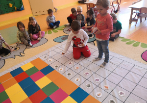 dzieci układają rytm na przemiennie dwa liście fioletowe i jeden pomarańczowy