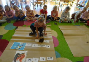 dzieci na dywanie układały zdania z rozsypanek wyrazowych w połączniu z ilustracjami i darami jesieni