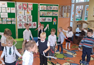 dzieci na dywanie tańczą z bibułowymi tasiemkami białą i czerwoną