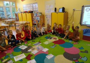 dzieci na dywanie wykonują polecenia nauczyciela