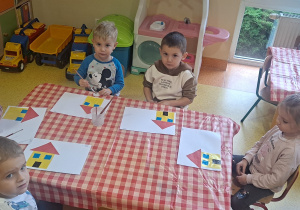 dzieci przyklejały drzwi, okna na wcześniejszy żółty kwadrat oraz czerwony trójkąt tworzący dach