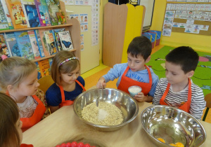 dzieci wrzucają składniki na owsiane ciasteczka do miski