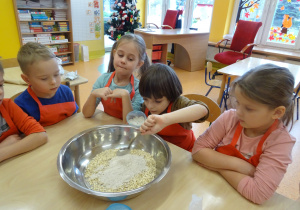 dzieci wrzucają składniki na owsiane ciasteczka do miski