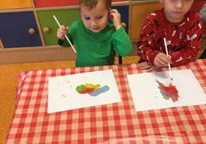 dzieci wykonały kolorowego stworka poprzez dmuchanie na plamy z farb przez słomkę do picia