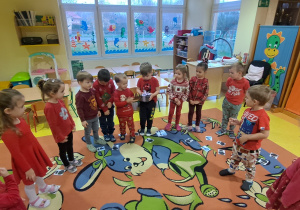 dzieci brały wspólnie udział w zabawach Mikołajkowych na dywanie oraz przy stolikach