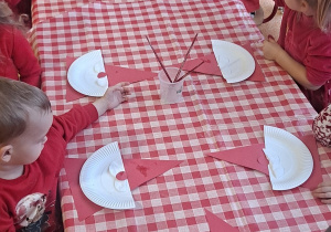 dzieci brały wspólnie udział w zabawach Mikołajkowych na dywanie oraz przy stolikach