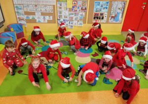 dzieci wspólnie bawiły się i grały w zabawy zorganizowane przez nauczyciela na dywanie