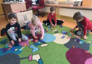 dzieci podczas zabaw matematycznych układały klocki Numicon w kolejności wzrastającej, rozpoznawały wzrokiem i dotykiem kształty Numicon, nazywały ich kolor i liczebność,  szukały  liczb składowych (sumy) wskazanej liczby za pomocą różnych kombinacji klocków Numicon, które potem układały.