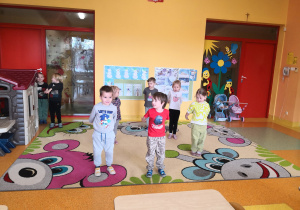 dzieci na dywanie wykonują polecenie nauczyciela w zabawie ruchowej