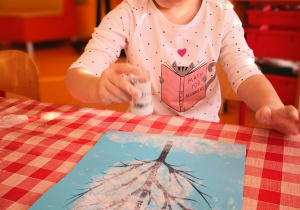 dzieci przy stolikach malują folię bąbelkową i odbijają ją na kartce z suchym drzewem