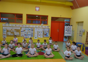 dzieci na dywanie wykonują ćwiczenia wskazane przez nauczyciela - medytują