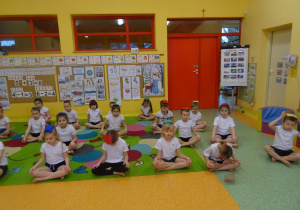 dzieci na dywanie siedzą po turecku