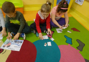 dzieci układają pocięte ilustracje ze zwierzętami i ludźmi z Arktyki