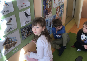 dzieci wieszają ilustracje na tablicy