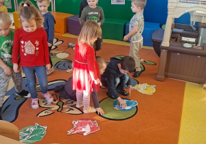 dzieci spośród ptaków na dywanie szukają wskazanych przez nauczyciela i grupują je wg koloru