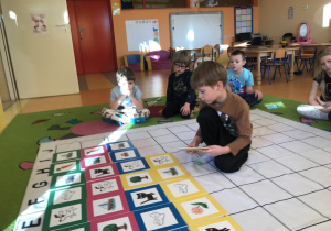 dzieci kodują na dywanie według ustalonego wzoru