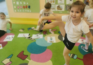 dzieci wykonują ćwiczenia zgodnie z ilustracją przy, której się zatrzymują