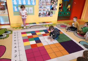 dzieci odwzorowują podany układu kolorowych tabliczek na macie współpracując w parach