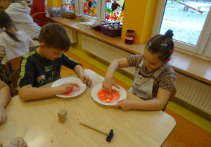 dzieci przy stolikach badały ciecz newtonowską i barwią ją farbą