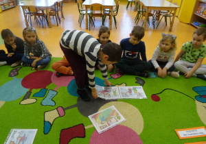 chłopiec układa historyjkę obrazkową z ilustracji na dywanie
