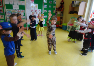 dzieci w strojach karnawałowych tańczą i wyrażają ruchem treść muzyki