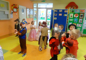 dzieci w strojach karnawałowych tańczą i wyrażają ruchem treść muzyki