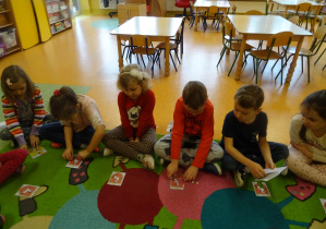 grupa na dywanie układa różne puzzle związane z Koninem