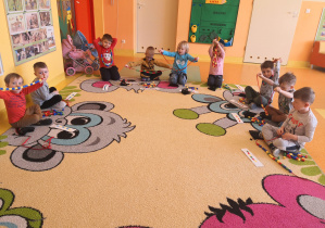 dzieci prezentują wykonane zadanie czyli prawidłowo ponawlekane kolorowe kołeczki