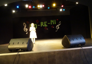 dziewczynka śpiewa na scenie przygotowana piosenkę
