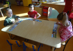 dzieci przy stolikach układają obrazki w kolejności dotyczące drogi mleka do naszych domów