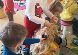 przedszkolaki zamienieni we fryzjerów suszą peruki, układają fryzury