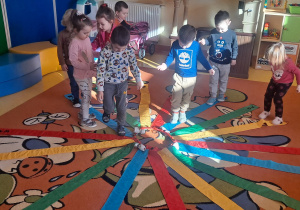 dzieci na wiatraku matematycznym składającym się z kolorowych wstążek szukały koloró wskazanych przez nauczyciela