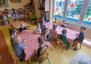 dzieci przy stolikach kulały kuleczki z bibuły służące jako pąki drzew