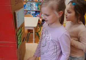 dzieci bawią się w korzystanie ze zrobionego przez grupę bankomatu