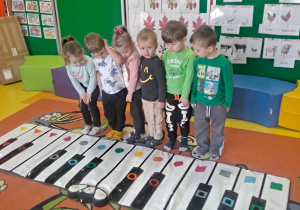 dzieci w podziałem na grupy zagrały na klawiszach kolor piano stopami