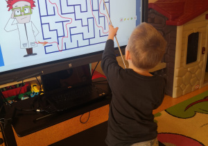 chłopiec na ekranie wskazuje prawidłową ścieżkę w labiryncie