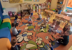 dzieci na dywanie utrwalają liczenie za klockach Numikon