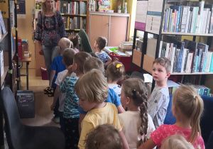 dzieci z zainteresowaniem oglądają zbiory biblioteki