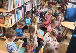dzieci oglądają książki zebrane w bibliotece
