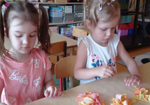 dzieci przy stolikach wąchały, dotykały oraz układały wzory z płatków róż