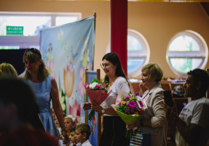 rodzice wręczają kwiaty nauczycielom w geście podziękowania
